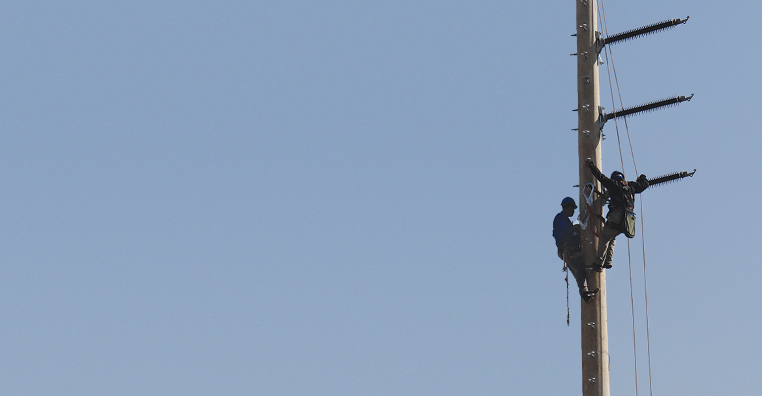 Two men working on an urban transmission line