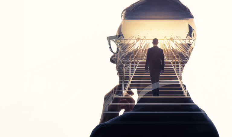 A man on a flight of stairs superimposed on silhouette of a thinking man