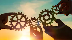 Four hands holding up gears signifying innovation