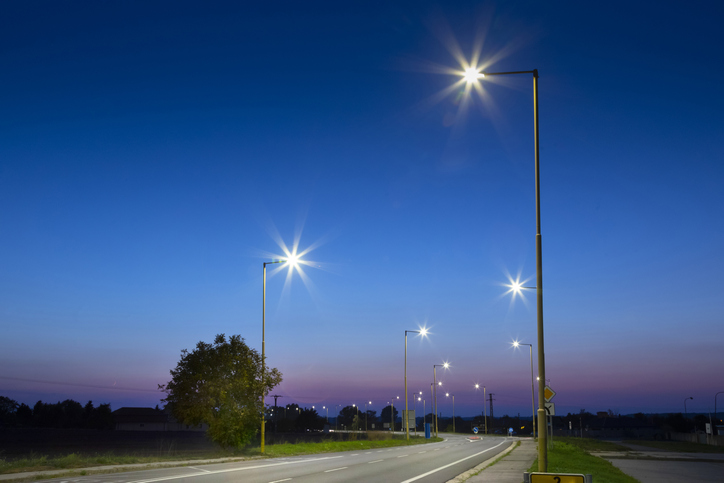 A road with lampposts and tress on either side of it