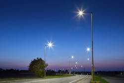A road with lampposts and tress on either side of it A road with lampposts and tress on either side of it