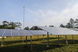 A wind turbine and a range of solar panels A wind turbine and a range of solar panels