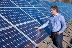 Matthew Reno with his hand on an array of solar panels Matthew Reno with his hand on an array of solar panels