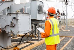 A worker looking at a transformer A worker looking at a transformer