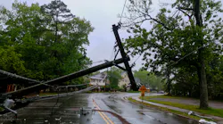 Damaged power lines hanging over a road after a storm
