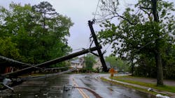 Damaged power lines hanging over a road after a storm Damaged power lines hanging over a road after a storm