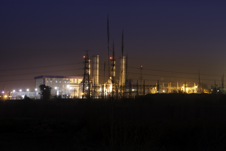 A nightscape showing buildings, electric transmission towers and overhead lines