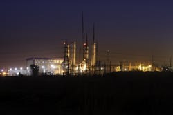 A nightscape showing buildings, electric transmission towers and overhead lines A nightscape showing buildings, electric transmission towers and overhead lines
