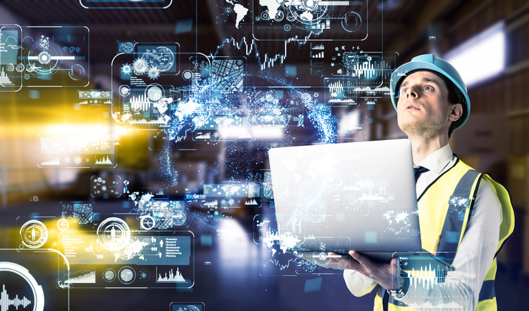 A man with a laptop examining data on futuristic hologram