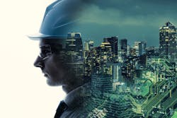 A composite image of an engineer's face and an illuminated city scape A composite image of an engineer's face and an illuminated city scape