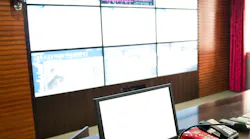 A utility control room with a computer, microphone, and telephones