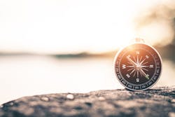 A compass placed upright on the ground A compass placed upright on the ground
