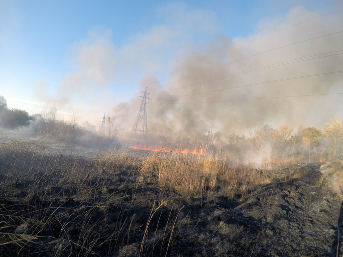 Electric transmission towers obscured by smoke from a wildfire