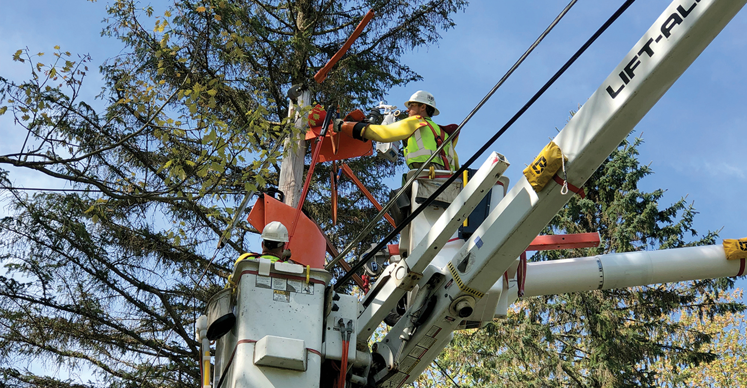 Penn Power line workers install a new TripSaver device on a power line
