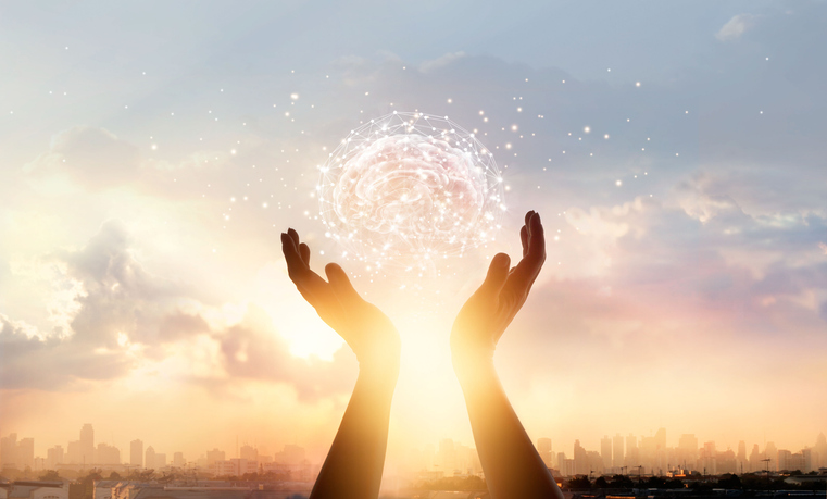 A pair of hands supporting a floating brain surrounded by a network of lights