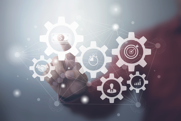 A finger touching an interconnected network of gears on a digital screen