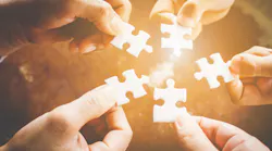 Hands holding pieces of a jigsaw puzzle