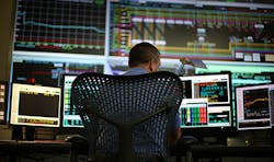 A man working with data on multiple computers A man working with data on multiple computers