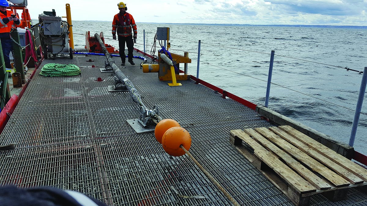 Sealed cable end with floatable markers, ready to be lowered to seabed. Yellow-colored subsea cable cutting tool also depicted.