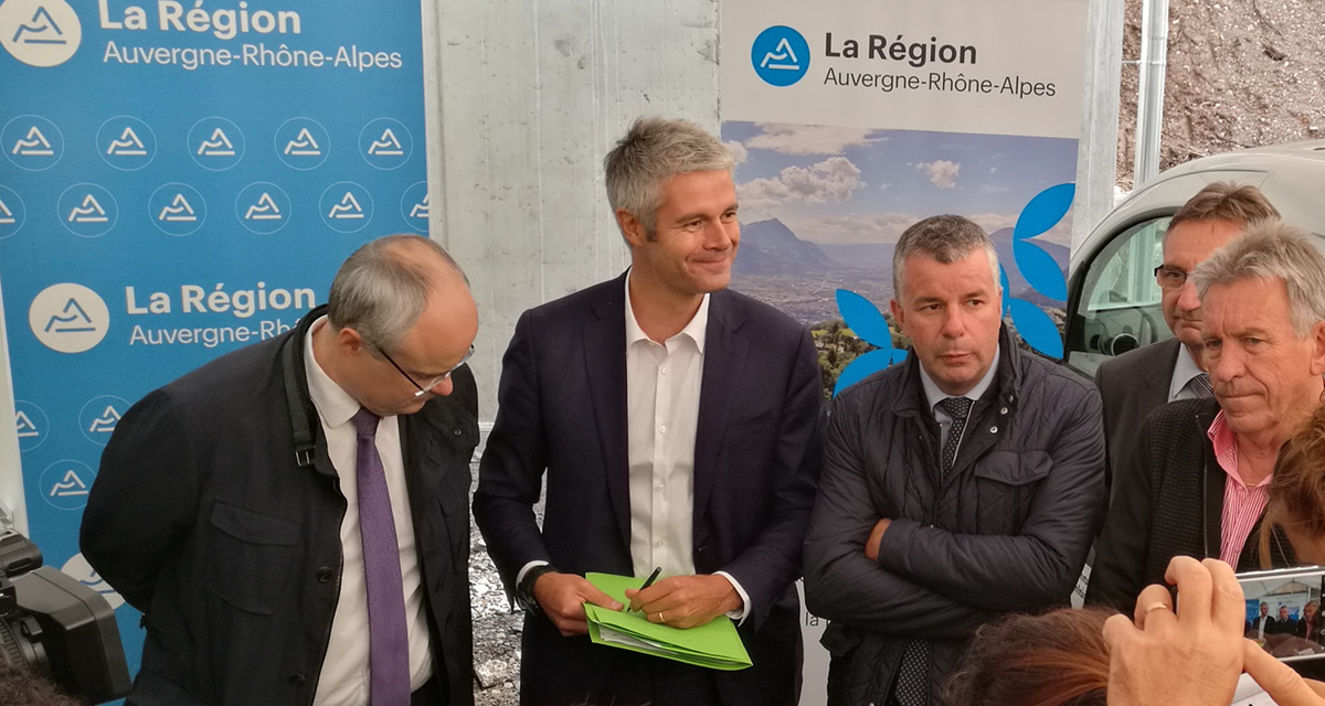 A group of people standing in front of Auvergne Rh&ocirc;ne-Alpes banners