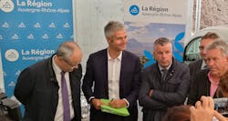 A group of people standing in front of Auvergne Rhône-Alpes banners A group of people standing in front of Auvergne Rhône-Alpes banners