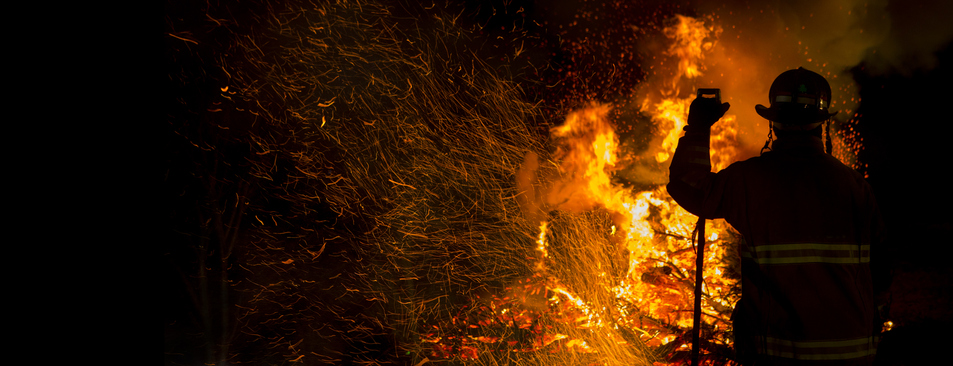Utility worker in front of a wildfire
