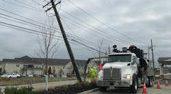 Utility workers on trucks assisting in storm restoration Utility workers on trucks assisting in storm restoration