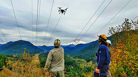 BPA&rsquo;s transmission line crew receives sock line from the quadcopter under the de-energized portion of the Lolo Pass line.
