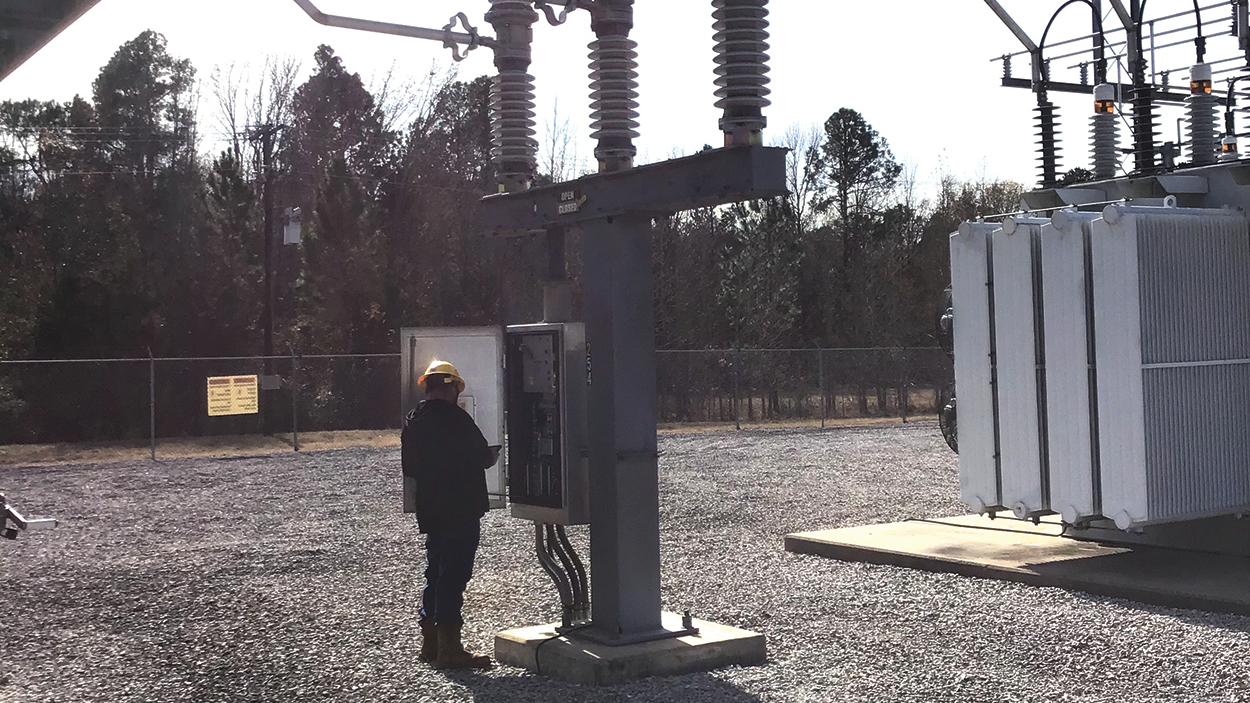 Brandon Lankford, WCEC power quality technician, performs an inspection on a circuit switcher.