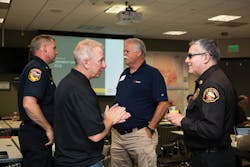 Troy Whitman (second from left), SCE Fire Management officer, discusses Operation Santa Ana with L.A. County Fire Department Assistant Chief J. Lopez (far right). Troy Whitman (second from left), SCE Fire Management officer, discusses Operation Santa Ana with L.A. County Fire Department Assistant Chief J. Lopez (far right).