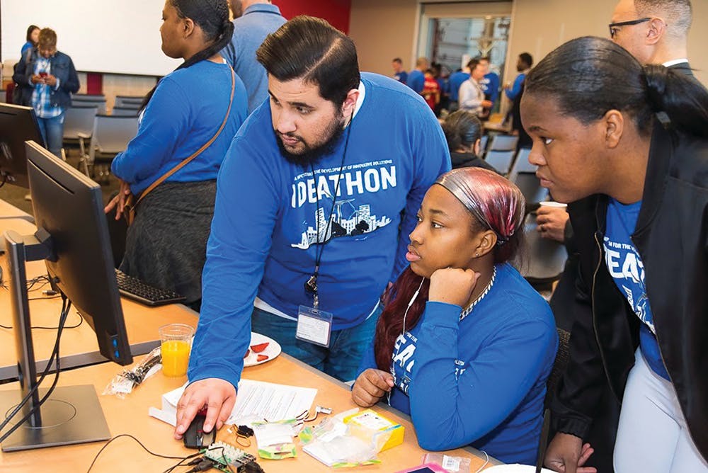 Mentor leads ComEd STEM program students in project research.