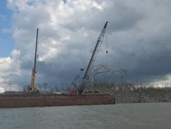 After locating a downed transmission tower in the Cumberland River, crews used cranes mounted on a barge to remove the twisted metal from the river. After locating a downed transmission tower in the Cumberland River, crews used cranes mounted on a barge to remove the twisted metal from the river.