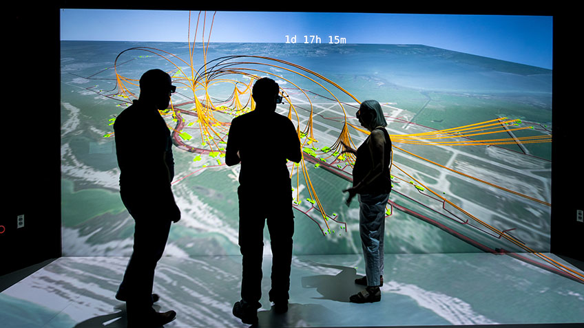 NREL scientists Evan Rosenlieb, Nicholas Brunhart-Lupo, and Amy Schwab look at a 3D visualization of a resiliency study for Tyndall Air Force Base.