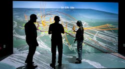 NREL scientists Evan Rosenlieb, Nicholas Brunhart-Lupo, and Amy Schwab look at a 3D visualization of a resiliency study for Tyndall Air Force Base.