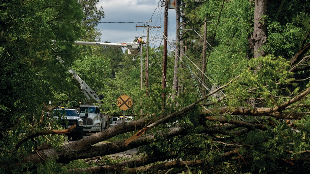 Entergy Texas crews and other contractors work to clear debris, set new poles and restore power in downtown Smackover, Arkansas, on April 14, 2020.