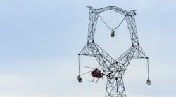 A helicopter guided wire through pulleys. Once the first phase of stringing was finished, the small-gauge cable was attached to another thicker cable and pulled back through the pulleys. The thicker cable was used to pull the final conductor into place.