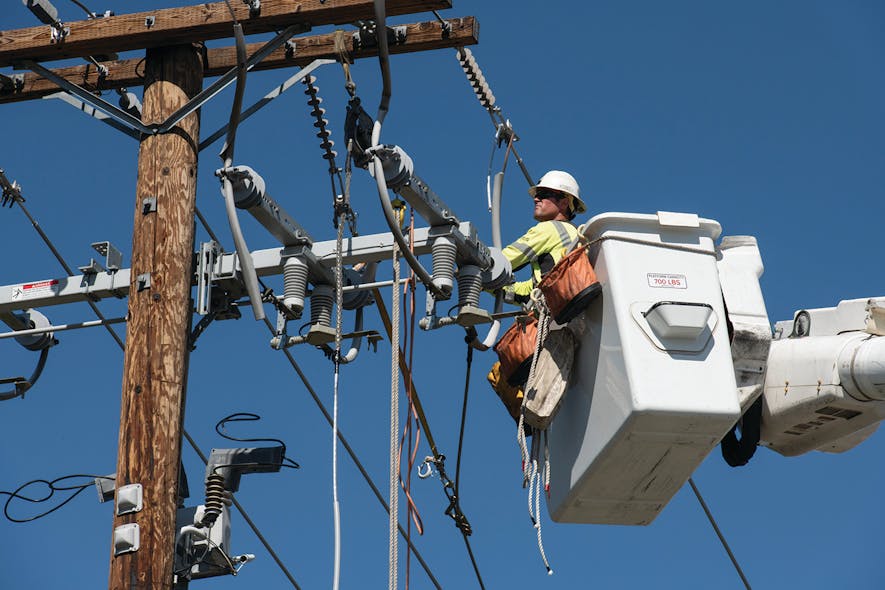 A Southern California Edison lineman is in a bucket truck installing covered conductor around distribution equipment. Covered conductors are a critical aspect to wildfire mitigation work.