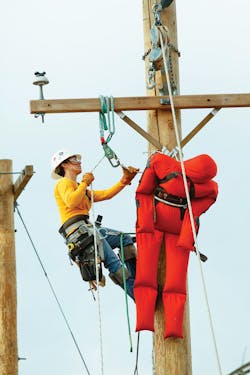 An electrical lineworker student performs a hurtman rescue. An electrical lineworker student performs a hurtman rescue.
