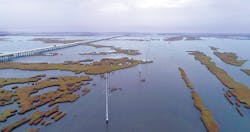 Transmission lines send electricity from centralized power generation stations (located about 60 miles away) across a marsh near Port Fourchon, Lafourche Parish. Transmission lines send electricity from centralized power generation stations (located about 60 miles away) across a marsh near Port Fourchon, Lafourche Parish.