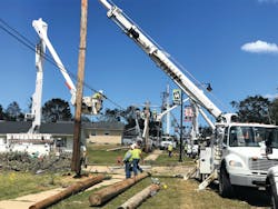 Crews line a street near downtown Marion, Iowa, to repair downed lines and replace poles. Crews line a street near downtown Marion, Iowa, to repair downed lines and replace poles.