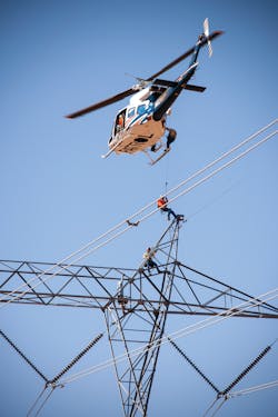 Aerial line workers inspect lines for damage.