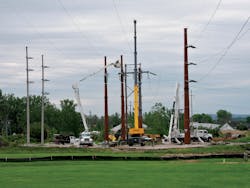 Three Phase Line crews maneuver equipment situated atop timber mats into position to pull new wire and attach it to new steel transmission structures. Three Phase Line crews maneuver equipment situated atop timber mats into position to pull new wire and attach it to new steel transmission structures.
