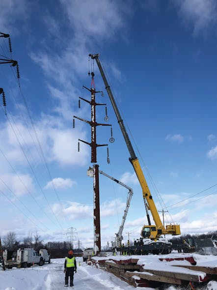 Three Phase Line crews use a mobile telescoping crane to assist in connecting a new Cor-Ten steel transmission tower near Cicero, New York, for National Grid.