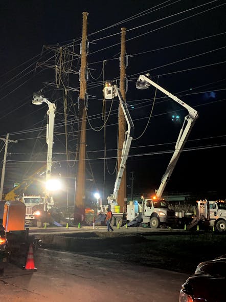 Working through the night to minimize disruption across a state highway crossing, Three Phase Line crews transfer a conductor from an old structure (in the background, to a new one in the foreground).