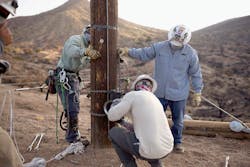 SRP crews install a capstan hoist on pole, preparing to pull wire back up on pole. SRP crews install a capstan hoist on pole, preparing to pull wire back up on pole.