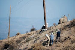 SRP crews plumb a pole with rope after a helicopter set. The two employees next to the pole are adjusting the wedges. SRP crews plumb a pole with rope after a helicopter set. The two employees next to the pole are adjusting the wedges.