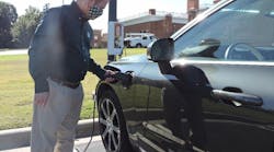 Dr. Rob Keynton, dean of the William States Lee College of Engineering, connects his plug-in hybrid electric vehicle to a Pole Volt charger (background) as part of early testing before a year-long public trial in Charlotte, North Carolina.