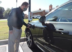 Dr. Rob Keynton, dean of the William States Lee College of Engineering, connects his plug-in hybrid electric vehicle to a Pole Volt charger (background) as part of early testing before a year-long public trial in Charlotte, North Carolina.