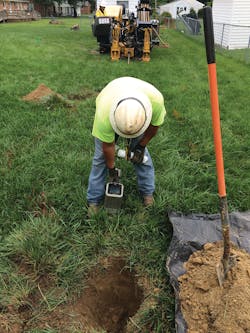 Contractor monitors underground cable pull.