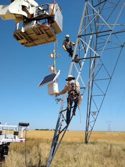 Utility linesmen installing the LineVision non-contact power line monitoring system.